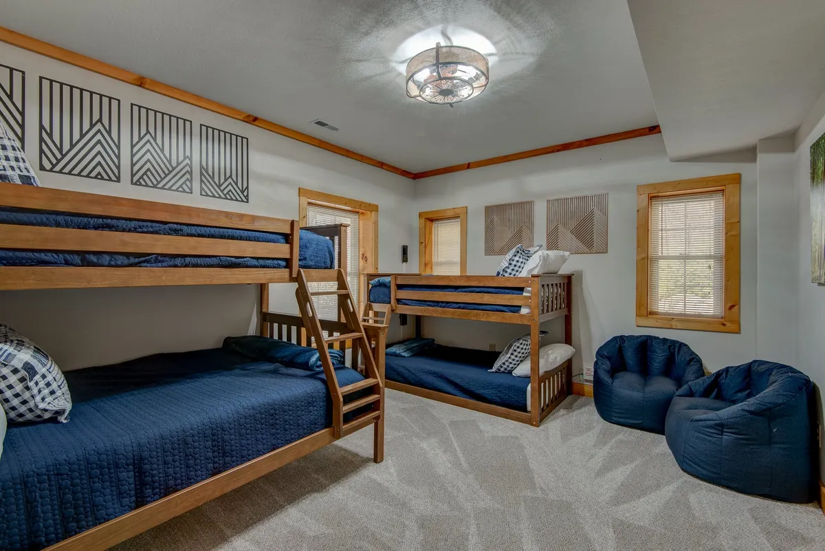 A playful guest room featuring bunk beds, bean bag chairs, and decorative wall art. The relaxed atmosphere is ideal for children or groups seeking a fun and cozy hangout spot.